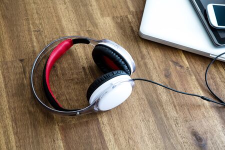 A Laptop computer, Headphones, a Tablet PC and a Smartphone on a wooden Desktop.の写真素材
