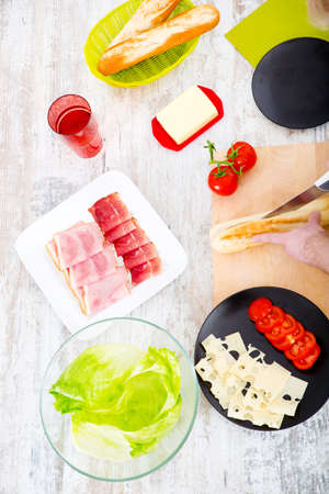 A young man preparing a sandwich in the kitchen.
の写真素材