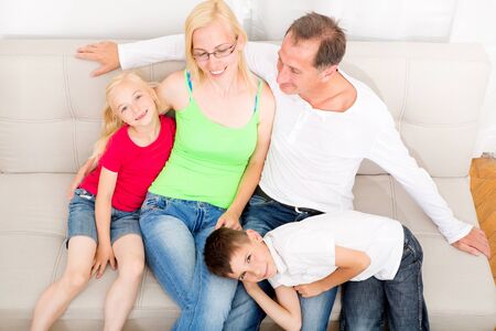 Happy family sitting together on the couch