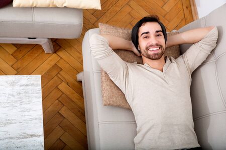 Young man relaxing on the sofa at homeの写真素材