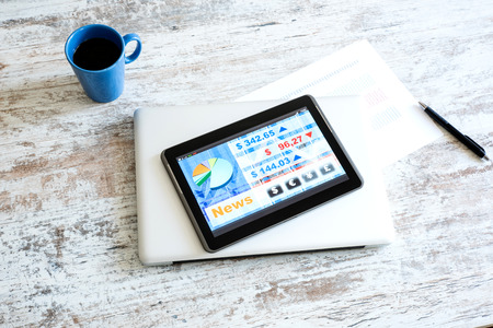 Stock market trading and research software on a Tablet PC on a office Desktop with a Laptop computer.の写真素材