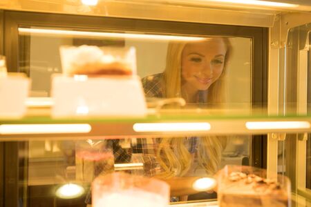 A beautiful young woman ordering from a nice girl at the bar in a coffee shopの写真素材