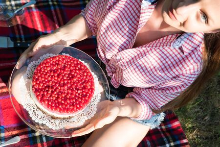 A young woman having a picnic with a cake in the garden.の写真素材