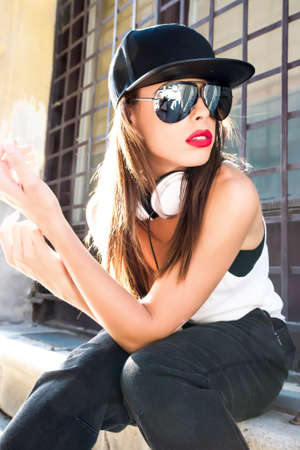 A beautiful young Hip Hop Rapper girl with Headphones in a urban environment.の写真素材
