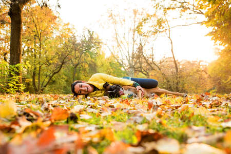 Beautiful young woman with her Dog in the Park in the autumn.の写真素材