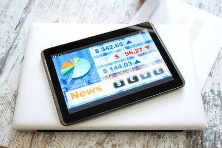 Stock market trading and research software on a Tablet PC on a office Desktop with a Laptop computer.の写真素材