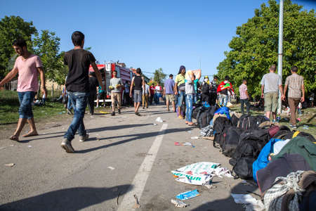 TOVARNIK, CROATIA - SEPTEMBER 18: Stranded Refugees form a waiting line in order to get a transported further towards northern Europe on September 18, 2015 in Tovarnik, Croatia.のeditorial素材