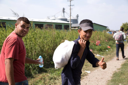 TOVARNIK, CROATIA - SEPTEMBER 18: Refugees happy to arrive to Croatia after crossing the Serbian border on September 18, 2015 in Tovarnik, Croatia.のeditorial素材