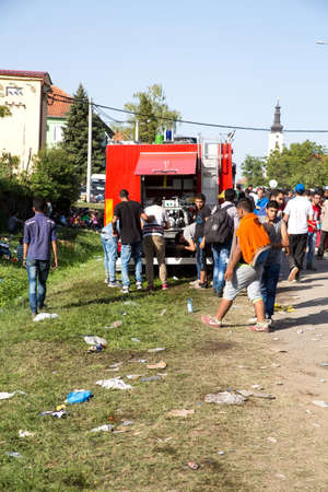 TOVARNIK, CROATIA - SEPTEMBER 18: The local Fire Brigade provides water to Refugees who arrive from Serbia on September 18, 2015 in Tovarnik, Croatia.のeditorial素材