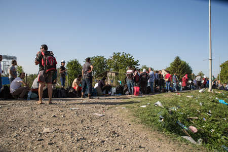 TOVARNIK, CROATIA - SEPTEMBER 18: Stranded Refugees form a waiting line in order to get a transported further towards northern Europe on September 18, 2015 in Tovarnik, Croatia.のeditorial素材