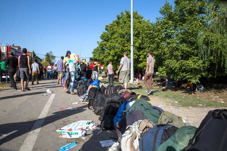 TOVARNIK, CROATIA - SEPTEMBER 18: Stranded Refugees form a waiting line in order to get a transported further towards northern Europe on September 18, 2015 in Tovarnik, Croatia.のeditorial素材