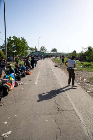 TOVARNIK, CROATIA - SEPTEMBER 18: Stranded Refugees form a waiting line with luggage after their arrival from Serbia on September 18, 2015 in Tovarnik, Croatia.のeditorial素材