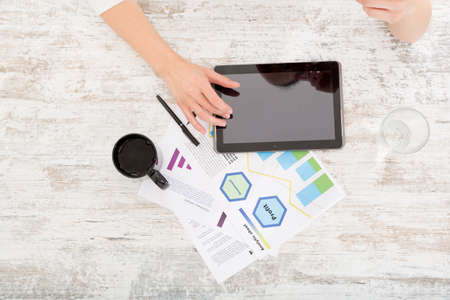 A young adult woman developing a business plan with her tablet PC at home.
