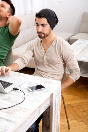 Two young men working in their home office