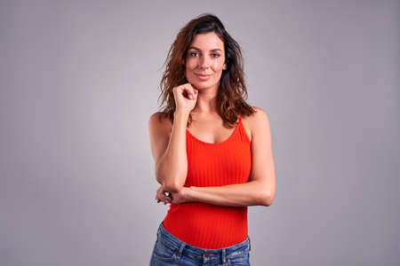 A beautiful young woman feeling happy in a red topの写真素材