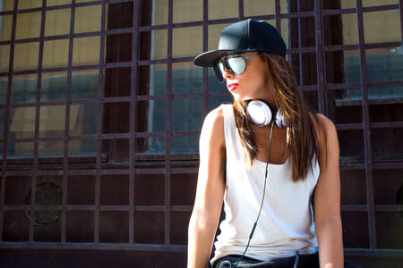 A beautiful young Hip Hop Rapper girl with Headphones in a urban environment.の写真素材