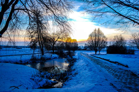View of a sunset over a winterly landscape in a rural environment in Germany, Europe.の写真素材