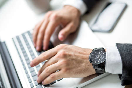 Hand of a business man while working on a laptop.の写真素材