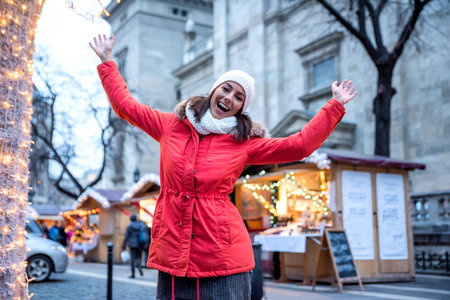 Portrait of a beautiful young woman next to a light gate on the christmas market.の写真素材