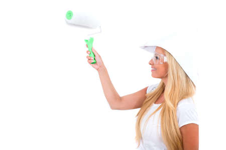 A beautiful young blond woman painting a white wallの写真素材