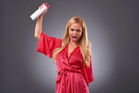 Young woman with a hairsprayの写真素材