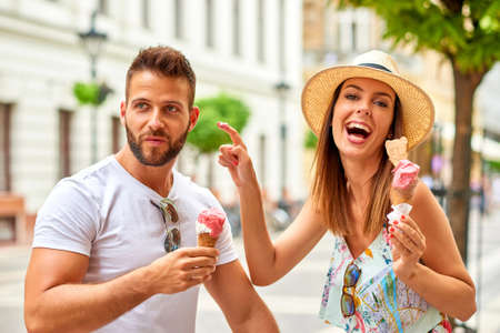 Young tourist couple with ice-creamの写真素材