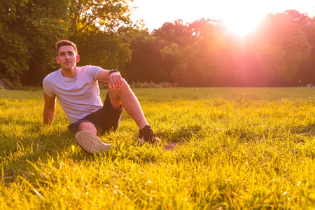 A young man sitting in the Grassの写真素材