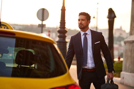 Young businessman with a taxiの写真素材