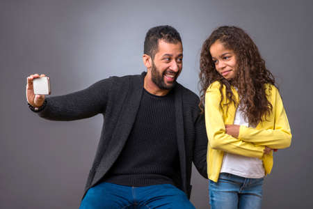 Black father taking selfie with his daughterの写真素材
