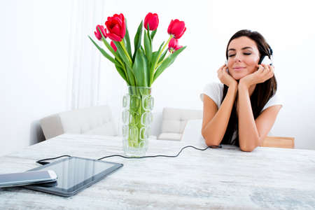 Portrait of a young beautiful woman listening to music with headphones