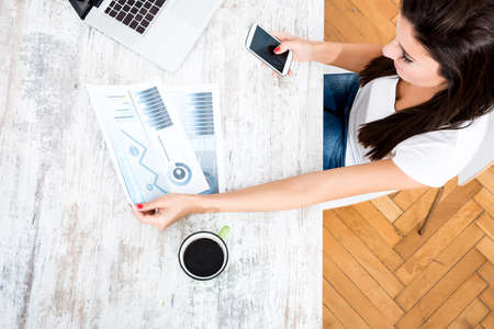 A young, beautiful business woman working from her home officeの写真素材