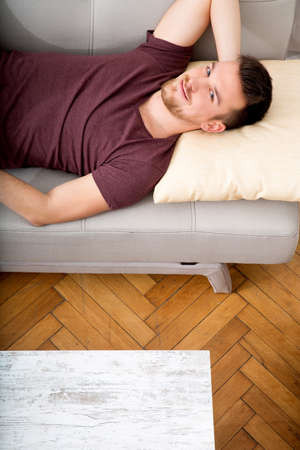 Young man relaxing on the sofa at homeの写真素材