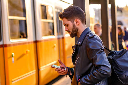 Young man waiting in a tram stationの写真素材