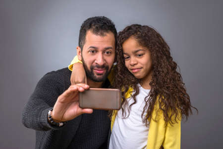 Black father taking selfies with his daughterの写真素材