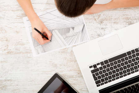 A young adult woman developing a architectural plan at home.の写真素材