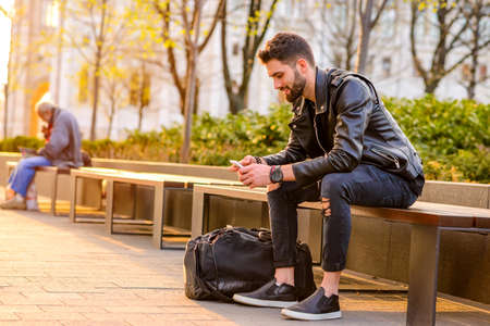 Young man sitting on a benchの写真素材