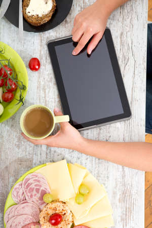 A womans hand with food and tabletの写真素材