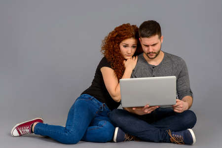 Nice young couple sitting in the studioの写真素材