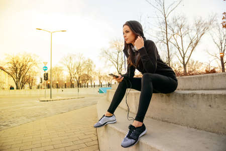 Young woman siting on the stairsの写真素材