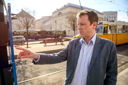 A middle age businessman at the tram stationの写真素材