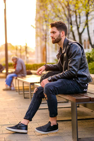Young man sitting on a benchの写真素材