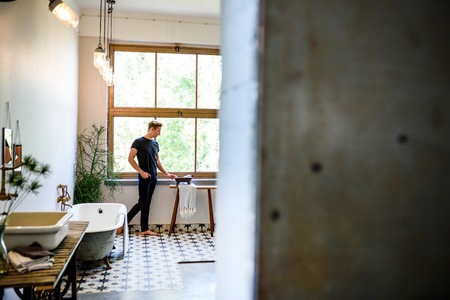 A young handsome man relaxing in a vintage style bathroomの写真素材