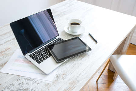Tablet PC and a Laptop PC on a wooden table with coffee and pen.の写真素材