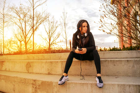 Young woman siting on the stairsの写真素材