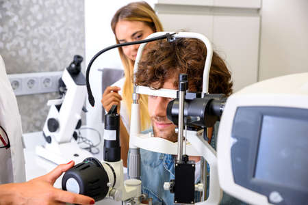 A young man getting a eye checkup at the ophthalmologistの写真素材