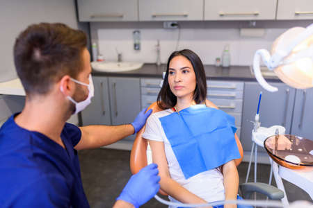 A young Dentist treating a female Patient in the dental studioの写真素材