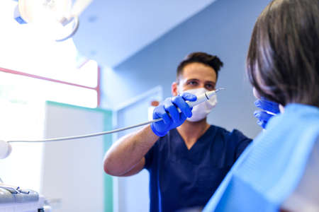A young Dentist treating a female Patient in the dental studioの写真素材