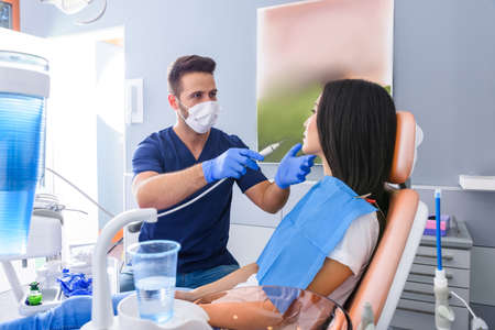 A young Dentist treating a female Patient in the dental studioの写真素材