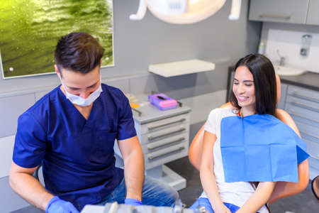 A young Dentist treating a female Patient in the dental studioの写真素材