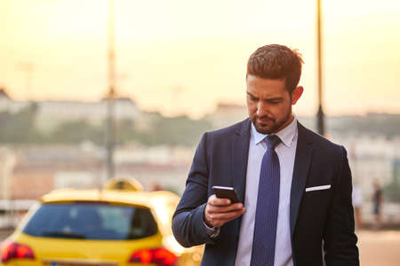Young businessman with a taxiの写真素材